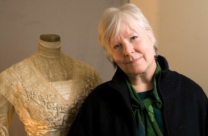 <p>Laura Crow, professor of dramatic arts, with a costume from the University’s historical collection. Photo by Frank Dahlmeyer </p>