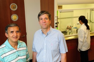 <p>Shantaram Hegde, left, professor of finance, and Joseph Golec, associate professor of finance, in a pharmaceutical lab. Photo by Peter Morenus</p>