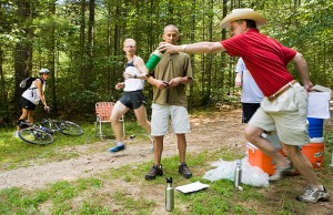 <p>Physical therapy professor Craig Denegar hands a drink to a runner during a dehydration study, as kinesiology professor Doug Casa looks on. Photo by Sean Flynn</p>