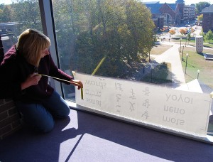 <p>Artist Linda Foster oversees installation of her project "Hamlet: A Cast of Shadows" at the Homer Babbidge Library. The project draws its inspiration from dialogue in Act ll of William Shakespeare's play. Photo by Suzanne Zack</p>