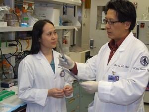<p>Drs. Bei Liu and Zihai Li discuss lab results. Photo by Chris DeFrancesco</p>