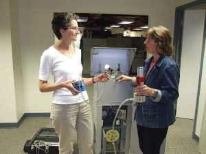 <p>Anne Bracker, left, and Nancy Simcox, research industrial hygienists, with an instrument used in an artificial turf study. Photo by Chris DeFrancesco</p>