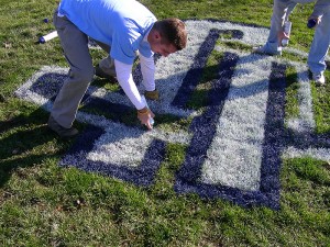 <p>Brian Tencza, along with his fellow students in the turfgrass program, put the final touches on the UConn field logo. Photo by Jason Henderson</p>