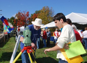 <p>Thomas Meyer, associate professor of natural resources and the environment, explains the workings of a ‘total station,’ a piece of equipment used in surveying, to participants in the Cornucopia Challenge scavenger hunt. Photo by Susan Schadt</p>