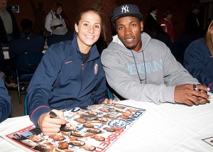 <p>Women's team player Caroline Doty and Jerome Dyson from the men's team sign autographs during 'First Night' at Gampel Pavilion. Photo by Stephen Slade</p>