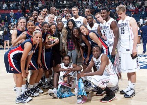 <p>The UConn Men's and Women's Basketball teams pose with recording artists Lloyd and  Amerie, center, during UConn 'First Night' festivities at Gampel Pavilion on Oct. 16 marking the start of the basketball season. Photo by Stephen Slade</p>