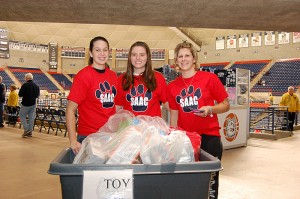 <p>A holiday toy drive at Gampel Pavilion during a basketball game, with Softball team members, from left, Brittany Duclos, Megan Apper, and Dana Hughes. Photo by Ken Best</p>