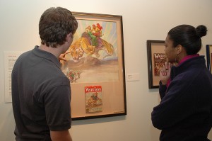 <p>Daniel Couture, left, a sophomore exploratory major, and Areal Allen-Stewart, a senior majoring in communications, check out one of the colorful pulp fiction covers at the Benton Museum. Photo by Margaret Malmborg</p>