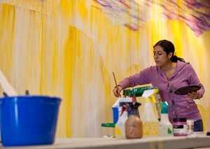 <p>Marela Zacarias, artist-in-residence at the Center for Latin American and Caribbean Studies, is painting a 10 x 18 foot mural  at the Center. Photo by Sean Flynn</p>