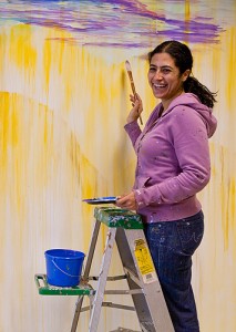 <p>Marela Zacarias, artist-in-residence at the Center for Latin American and Caribbean Studies, is painting a 10 x 18 foot mural  at the Center.  Photo by Sean Flynn</p>