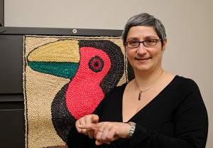 <p>Marie Coppola, assistant professor of psychology, makes the sign for "pay". Photo by Jessica Tommaselli</p>