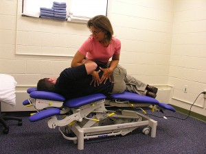 <p>Physical therapist Laurie Devaney demonstrates the Nayden Rehabilitation Clinic's new three-dimensional mobilization table that enables special treatment techniques for the spine. Photo by Janice Palmer</p>