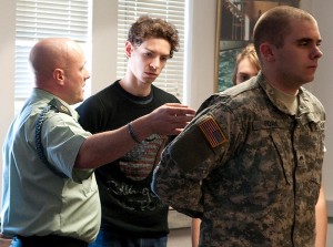 <p>Sergeant First Class John Maynard, left, and Cadet Chris Edam demonstrate various military conventions to help students Daniel Seigerman and Cayla Buettner prepare for an upcoming Connecticut Repertory Theatre production. Photo by Frank Dahlmeyer</p>