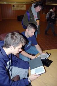 <p>Students try out Kindles in Homer Babbidge Library. Photo by Suzanne Zack</p>
