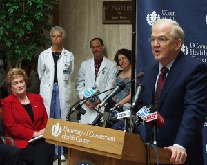 <p>President Michael Hogan comments on the new plan for the Health Center, as Gov. M. Jodi Rell and Health Center employees and supporters look on. Photo by Chris DeFrancesco</p>
