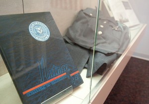 <p>A Nutmeg yearbook from 1941 and military uniform at the Huskies on the Home Front: The War Years at UConn exhibit, on display in the Dodd Research Center's gallery through June 11th. Photo by Frank Dahlmeyer</p>