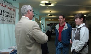 <p>Professor John Enderle speaks with Julia Ariola and her father, John, about Bio-Medical Engineering at the ITE building during Open House. Photo by Margaret Malmborg </p>