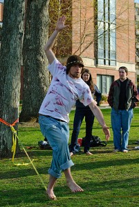 <p>Ryan Wheeler, a physiology and neurobiology graduate student, balances on a slackline outside the South Campus residence halls. Slacklining is similar to tight-rope walking except the "rope" is flat and not taut, and is positioned close to the ground. Photo by Jessica Tommaselli</p>