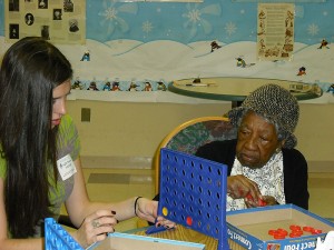 <p>Amanda Jankowski, left, plays Connect Four with a member of the Inglis House day care program during social game time. Photo supplied by the Office of Community Outreach</p>