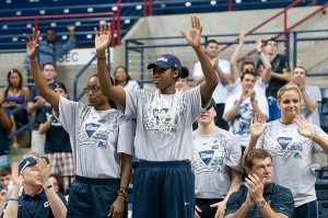 <p>Members of the UConn Women's Basketball team stand for a round of applause during the pep rally. At left is University President Michael Hogan, with Coach Geno Auriemma at right. Photo by Frank Dahlmeyer</p>
