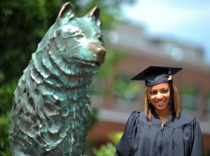 <p>Manuelissa Mota, a Spanish major, poses for a photo with the Jonathan Husky statue before the CLAS Commencement ceremony at Gampel Pavilion. Photo by Peter Morenus</p>