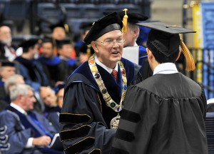 <p>President Michael Hogan congratulates doctoral candidates at the Graduate Commencement ceremony at Gampel Pavilion. Photo by Peter Morenus</p>