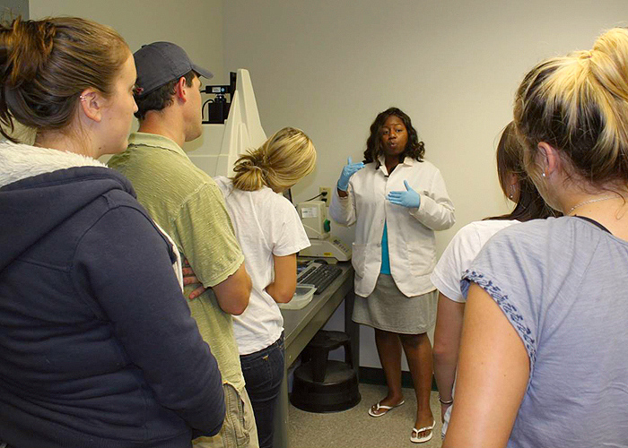 <p>Laboratory instructor Robin Walker, a fourth-year Ph.D student in plant sciences, explains results to students.  The DNA workshop has been held for five years, and local high schools such as E. O. Smith in Storrs, are incorporating lessons from the course into their curricula. Photo by Cameron Faustman.</p>