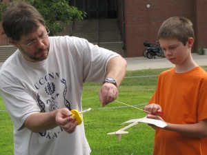 <p>With help from his instructor this student pilot from Ellington, prepared to attach the elastic band that powers the balsa wood craft. Photo by Sheila Foran</p>