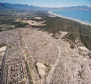 <p>The Macassar Dunes region of South Africa overlooks False Bay, the outskirts of Cape Town (foreground) and the Macassar indigenous community (background). Photo courtesy of John Silander</p>