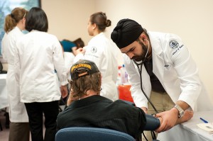 Hardeep Singh, a medical school student measures the blood pressure of a visitor to a clinic held at the East Hartford Community Health Center. (Peter Morenus/UConn Health Center Photo)