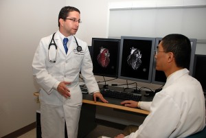 Drs. Erick Avelar (left) and Clifford Yang read cardiac CT images in the Department of Diagnostic Imaging and Therapeutics. Yang is one of Avelar's co-investigators in the Health Center's participation in the PROMISE study. (Janine Gelineau/UConn Health Center Photo)