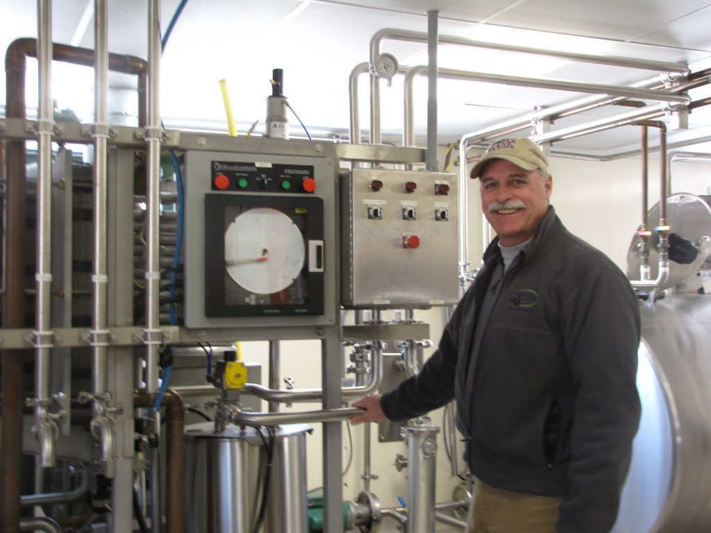 <p>Allyn Brown is shown with pasturizing equipment in his bottling plant at Maple Lane Farm. He ships hundAllyn Brown, with pasteurizing equipment in his bottling plant at Maple Lane Farm. He ships thousands of gallons of blackcurrant juice annually. (Sheila Foran/UConn Photo)