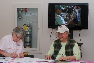 Pauline Bishop from Casting for Recovery (left) and UConn Health Center Auxiliary Facilitator Irene Engel accept registrations for the Auxiliary's pig roast fundraiser at Winding Trails in Farmington April 30. (Janine Gelineau/UConn Health Center Photo)