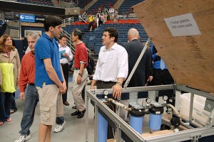 <p>Senior Joshua Cocciardi (right) shows his brother Mike the Solar Powered Water Filtration Unit to Produce Water for Bangladesh that he designed.  In Bangladesh, as in many third-world countries, potable drinking water is a major concern. Senior projects from the School of Engineering have  practical applications for real-world concerns. Photo by Ariel Dowski, CLAS '14 </p>