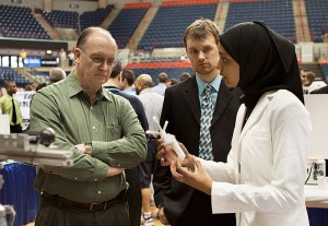 <p>Engineering student Khayriyyah Munir explains her team project on 3-D Ultrasound Reconstruction to a visitor. The project is sponsored by Dr. Joseph McIsaac, Biomedical Engineering, through Hartford Hospital. Using two-dimensional ultrasound and two low cost webcams, a virtual three dimensional image will be constructed. A similar product is on the market but its cost, at more than $100,000, is prohibitive for many clinical settings. The main purpose of this design project is to reproduce what has been done, but at very low cost. Photo by Christopher LaRosa</p>