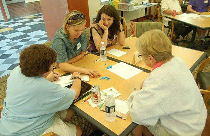Megan Staples, top center, an assistant professor of math education, watches as Hartford teachers work together on a math problem during a summer math ACCESS institute at UConn.