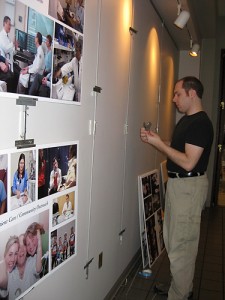 Jeff Eckleberry with Biomedical Media Communication prepares to hang 50th anniversary posters in the LOB. (Janine Gelineau/UConn Health Center Photos)