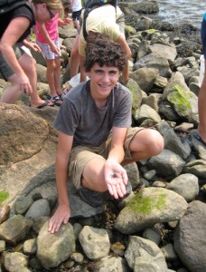 Justin Cleaves, age 14, of Canton, shows off a small crab he found while exploring the rocky shoreline during low tide at Avery Point.