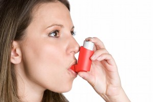 Woman using asthma inhaler