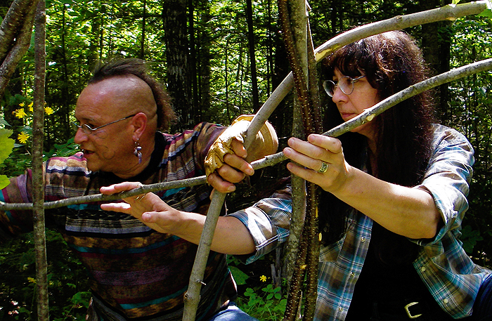 Gkisedtnamoogk, left, a Wampanoag educator and Native American Studies faculty member at the University of Maine, Orono, works with Marge Bruchac to construct a wigwam frame at a site on the Penobscot River.