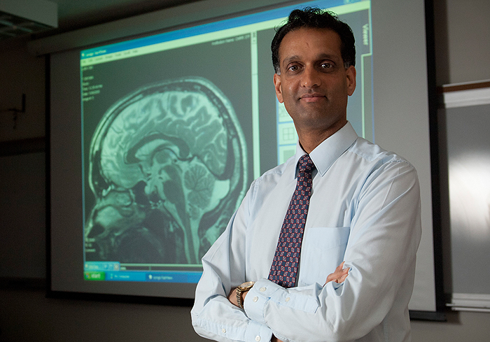 Pradeep Ramanathan, assistant professor of communication sciences, with a scan of his own brain.