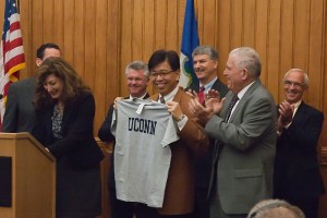 UConn President Susan Herbst and UConn Board of Trustees President Larry McHugh present Jackson Laboratory CEO Dr. Edison Liu with a UConn t-shirt at the governor's press conference at the Capitol on September 30, 2011. (Tina Encarnacion/UConn Health Center Photo)