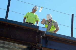 Construction workers stand on the second story of the building at the corner of Route 195 and Dog Lane.