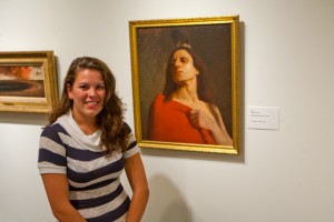 Alysha Elliard ’13 (SFA) with her assigned work, Indian, an oil painting by Mabel Woodward. (Sean Flynn/UConn Photo)