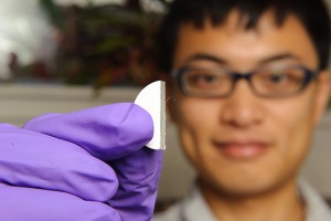 Ph.D. student Chen Jiang holds a coated sample. UConn is a leader in developing advanced thermal barrier coatings to reduce heat damage in gas turbines. (Peter Morenus/UConn Photo)