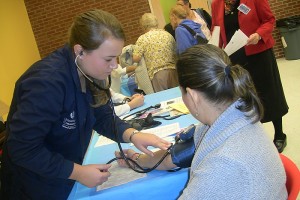 UConn nursing student monitors a patient's blood pressure at a Community Health Fair during Primary Care Week. (Photo provided by Shannon McClure)