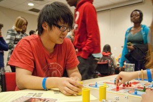 Xin Yu '13 plays Parcheesi, a board game thought to have originated in India, with Mo Yu '16 (not shown). (Max Sinton/UConn Photo)