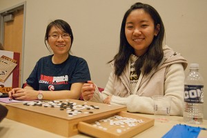 Yu Ji, left, a graduate student in statistics, and Yao Yi Wang '12 play and observe the game of Go, an ancient board game for two players that originated in China. (Max Sinton/UConn Photo)