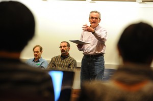 Arthur Wright, professor emeritus, speaks during "How do we get out of this mess" a panel discussion by economics departments members held at the Classroom Building on Nov. 16, 2011. Seated from left are Stephen Ross, professor of economics and Alanson Minkler, associate professor of economics. (Peter Morenus/UConn Photo)