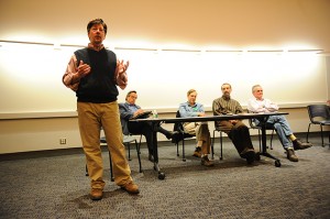 Steven Lanza, editor of The Connecticut Economy speaks during "How do we get out of this mess" a panel discussion by economics departments members held at the Classroom Building on Nov. 16, 2011. Seated from left are Fred Carstensen, Stephen Ross, Alanson Minkler, and Arthur Wright. (Peter Morenus/UConn Photo)